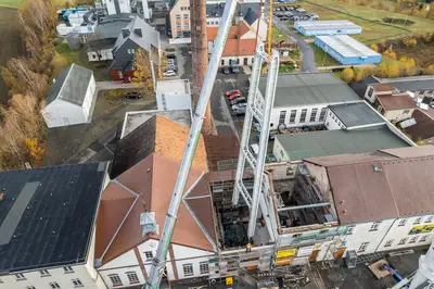 Mittels schwerer Krantechnik wird die sanierte Schrägstrebenstütze wieder eingehoben